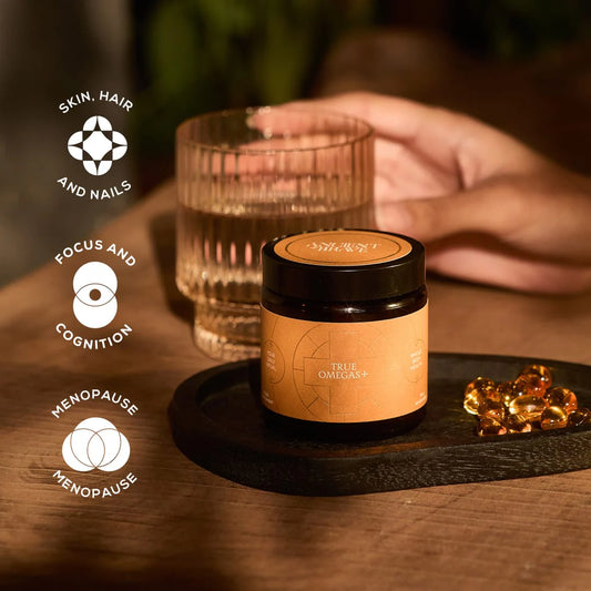 Jar of True Omegas+ on a wooden surface with icons and text about product benefits
